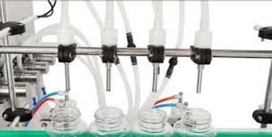 Automated machine filling bottles with liquid on a production line.