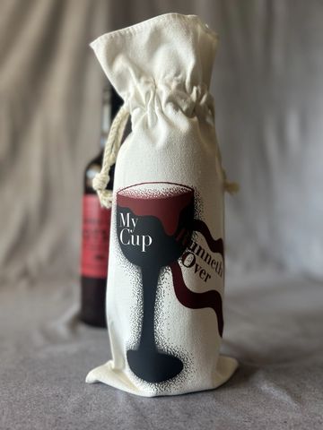 A fabric bag with a coffee cup design and text, containing a bottle.