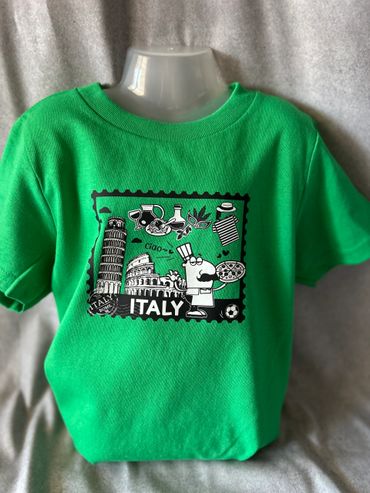 Green T-shirt with Italy-themed cartoon design showing pizza, Leaning Tower of Pisa, and Colosseum.