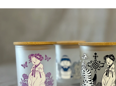 Frosted glass jars with bamboo lids, featuring cute character illustrations in various colors.