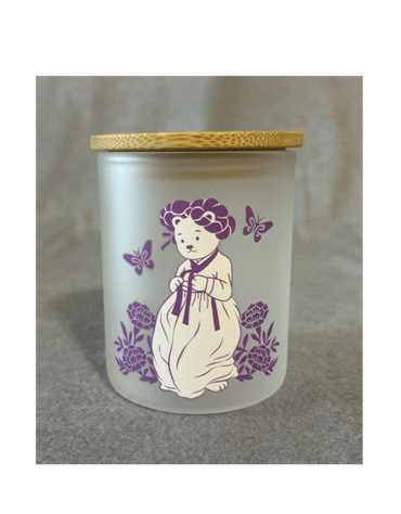 Frosted jar with wooden lid featuring a bear in traditional dress and purple butterflies.