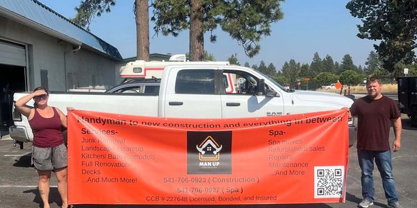 Cameron and Kaylynn hold a large orange banner