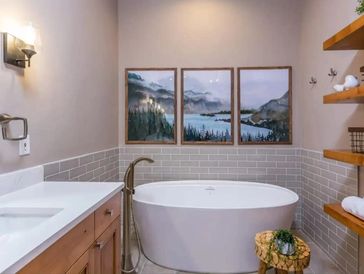 Beautiful free-standing tub adorning with a surrounding tile wall and remodeled sink in Bend Oregon.