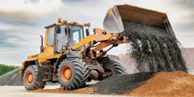 Yellow loader dumping gravel onto a pile at a construction site.