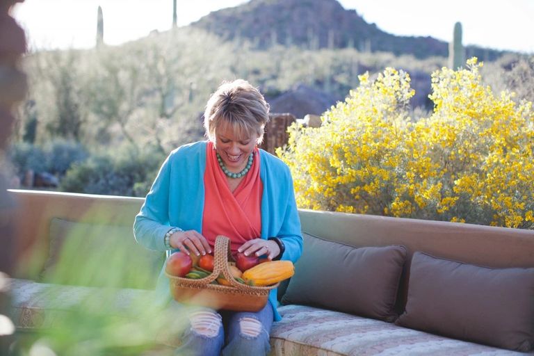 Penny with basket of vegetables on patio in Tucson.