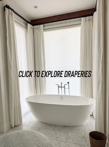 Modern bathroom with white draperies and a freestanding bathtub.