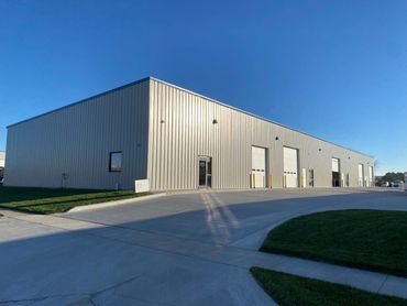 Large industrial warehouse building under clear blue sky.