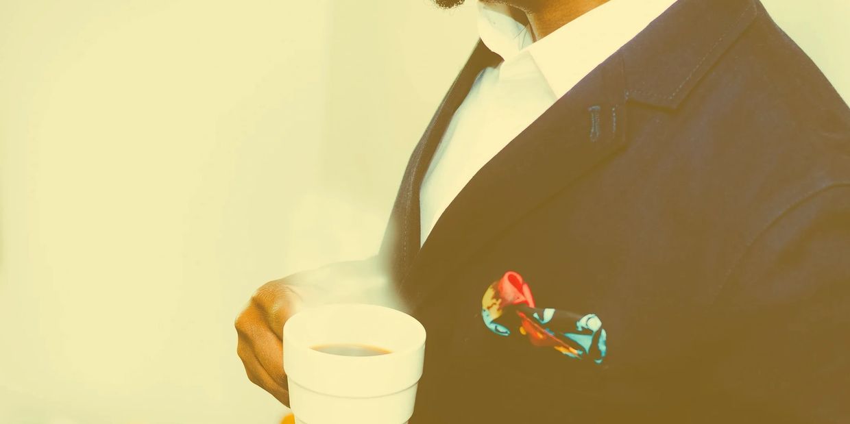 A guy holding a cup of coffee.