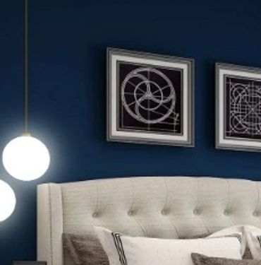 An image of a bedroom that is painted dark blue with cream accents.