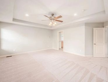 An image of an interior living room with freshly painted walls and new white carpet. A home that was