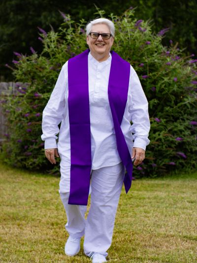 Rev. Terri Lytle-Holcomb in her clergy clothing outside walking with spiritual energy