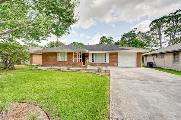 Single-story brick house with a well-kept front lawn.