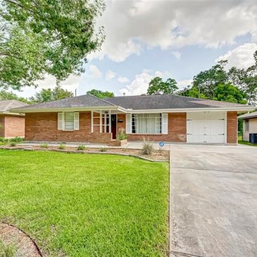 Single-story brick house with a well-kept front lawn.