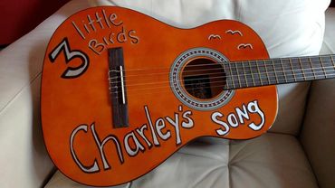 A guitar with Charley's song illustration on it