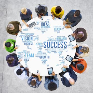 Diverse team brainstorming business success ideas around a table.