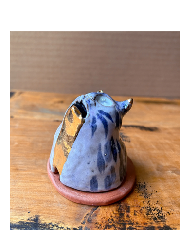 Incense burner shaped like the bust of a cat w/ an open mouth & gold flowing from mouth to base