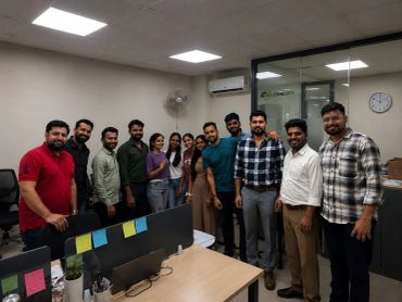 A group of colleagues posing together in an office setting.