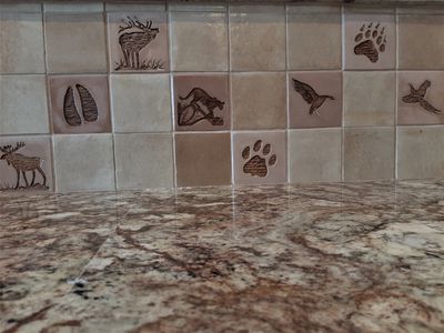 western ceramic tiles featuring animal tracks, wildlife and gamebirds added to a kitchen backsplash