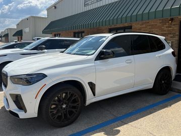 White luxury SUV parked outside a building.