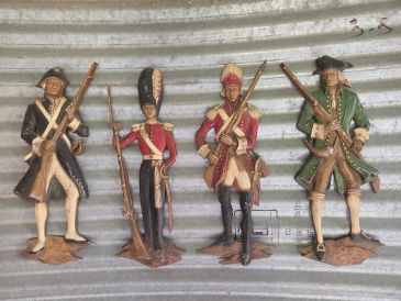 Four vintage soldier figurines with muskets.