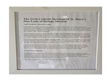 Plaque detailing The Irish Catholic Heritage of St. Mary's Our Lady of Refuge Mission.