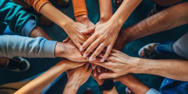 Multiple hands stacked together in a show of unity and teamwork, values, culture, people strategy