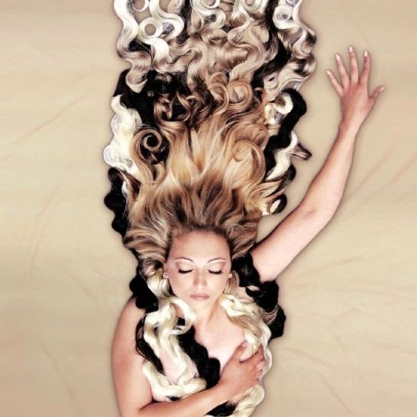 Logo of woman lying down with her hair flowing around her.