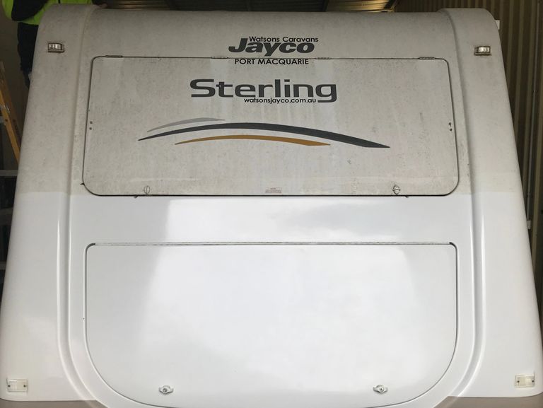 Back of caravan with fibreglass in current condition (dirty) on top half and restored on bottom half