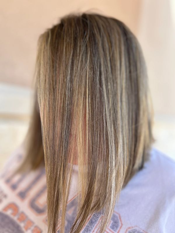 Blonde balayage highlights creating a sun-kissed look at a hair salon in San Antonio, TX