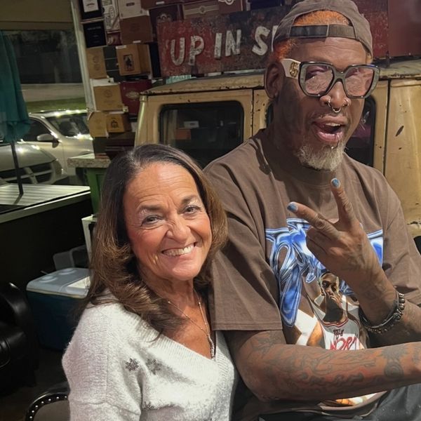 Two people smiling and posing together indoors.