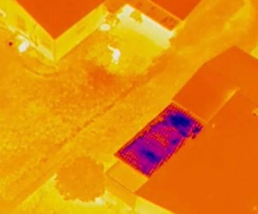Thermal image showing heat distribution on rooftops and ground surfaces.