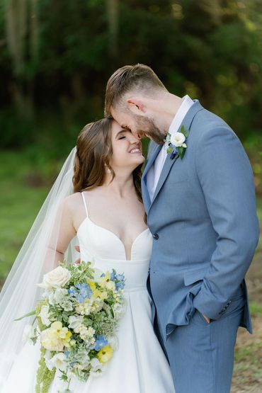 pale yellow, light blue, sage green and white wedding bridal bouquet and grooms boutonniere