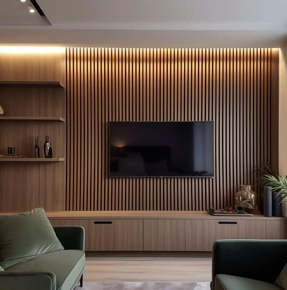 Modern living room with wood panel TV wall and green sofas.