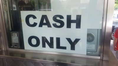 A sign stating 'CASH ONLY' displayed in a window.