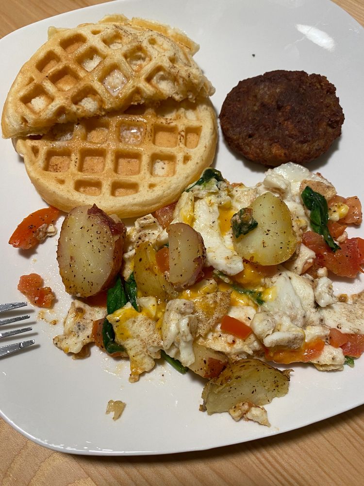 Waffle and our plant base sausage with homemade potatoes mixed with spinach, tomatoes and cheddar ch