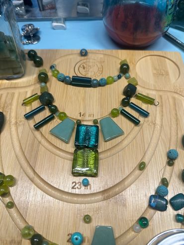 Colorful beads arranged on a wooden jewelry board for necklace making.