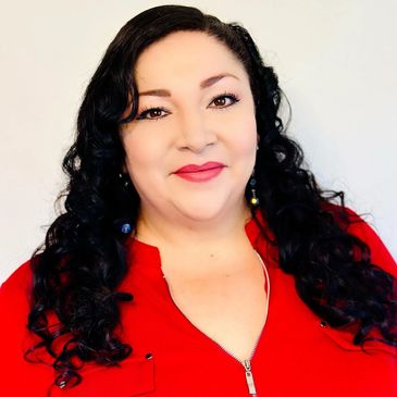 Smiling woman with curly hair wearing a red top.