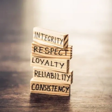 Wooden blocks stacked on top of each other with the words 'Integrity,' 'Respect,' and 'Loyalty.