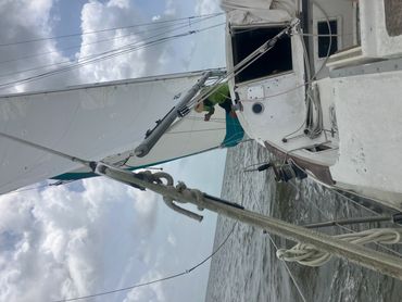 Sailboat gliding on the ocean under a cloudy sky.
