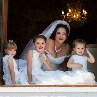 Bride and young bridesmaids looking out of window. Colorado wedding