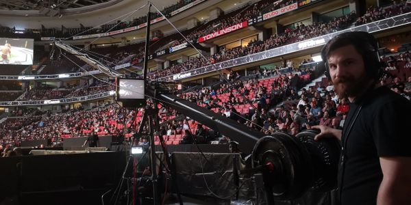 Man operates jimmy jib triangle camera crane