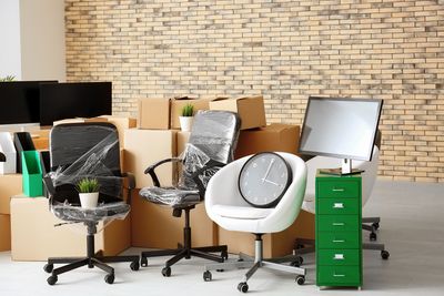 Office chairs and filing cabinet in room with packing boxes