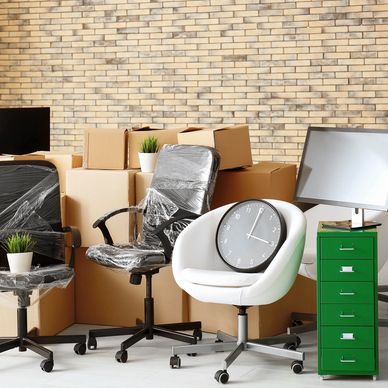 Office chairs and filing cabinet in a commercial room with packing boxes.
