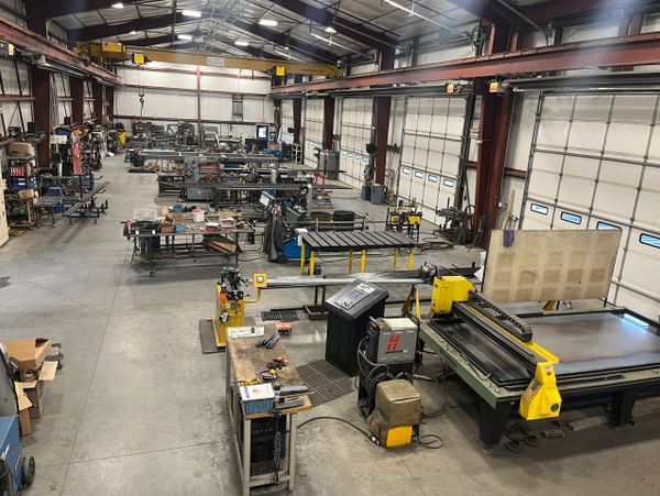 A spacious industrial workshop with metalworking machines and tools.