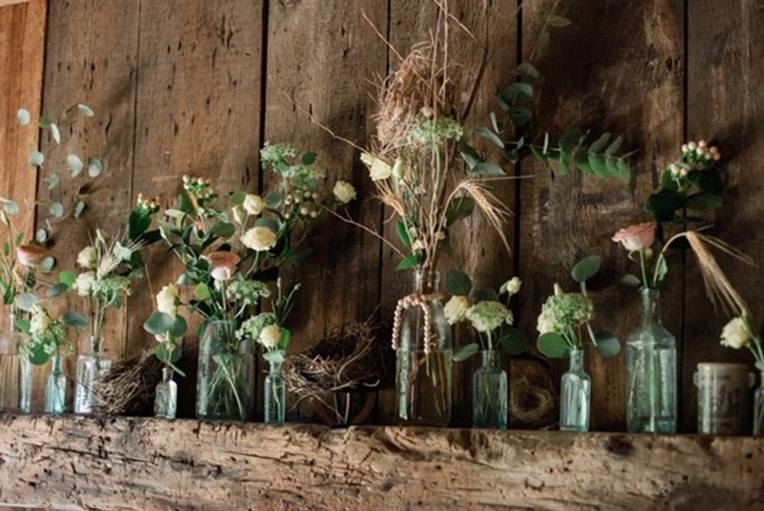 Flower arrangements in antique glass bottles