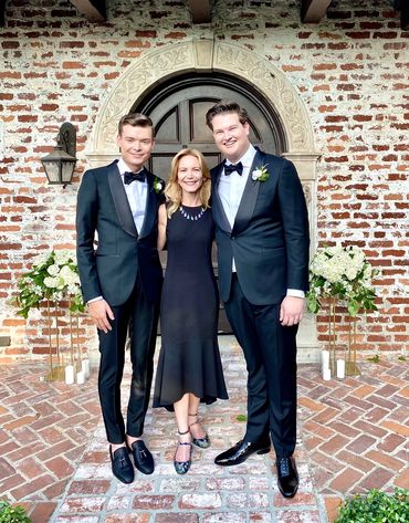 Jennie smiling with two grooms at their outdoor wedding ceremony in Orlando, Florida.