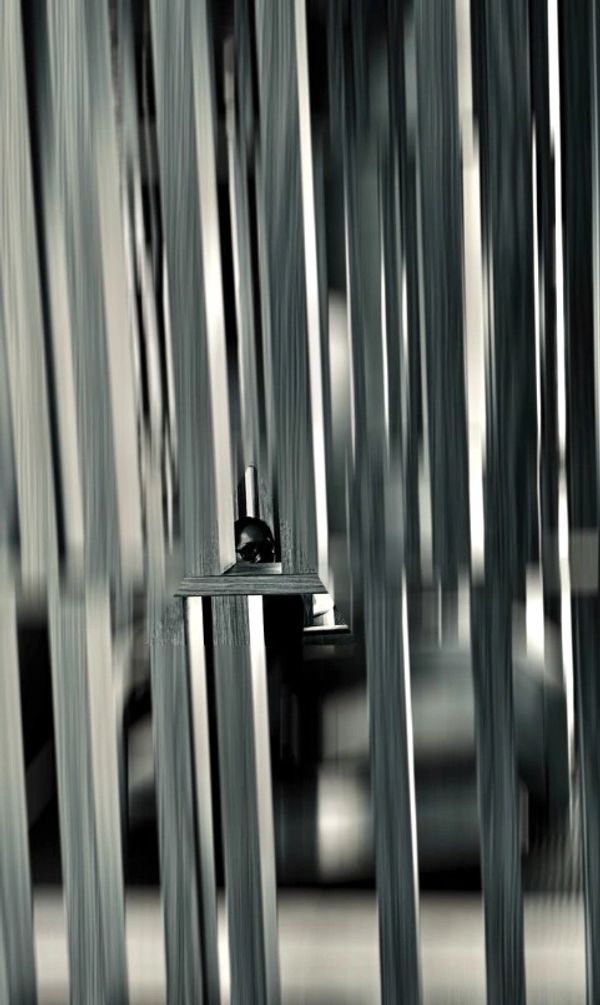 Abstract image with vertical lines and a person peeking through.