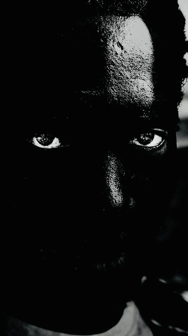 High contrast black and white close-up of a person's face with intense eyes.