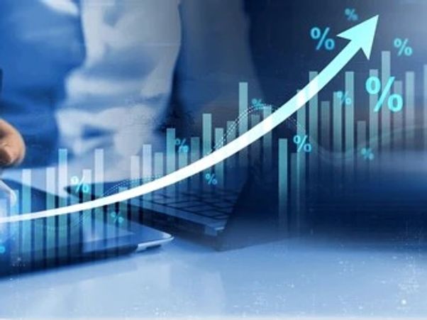 Person analyzing data with rising percentage graph and charts.