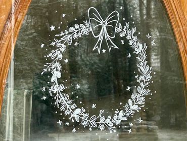 Painted window art featuring festive wreath